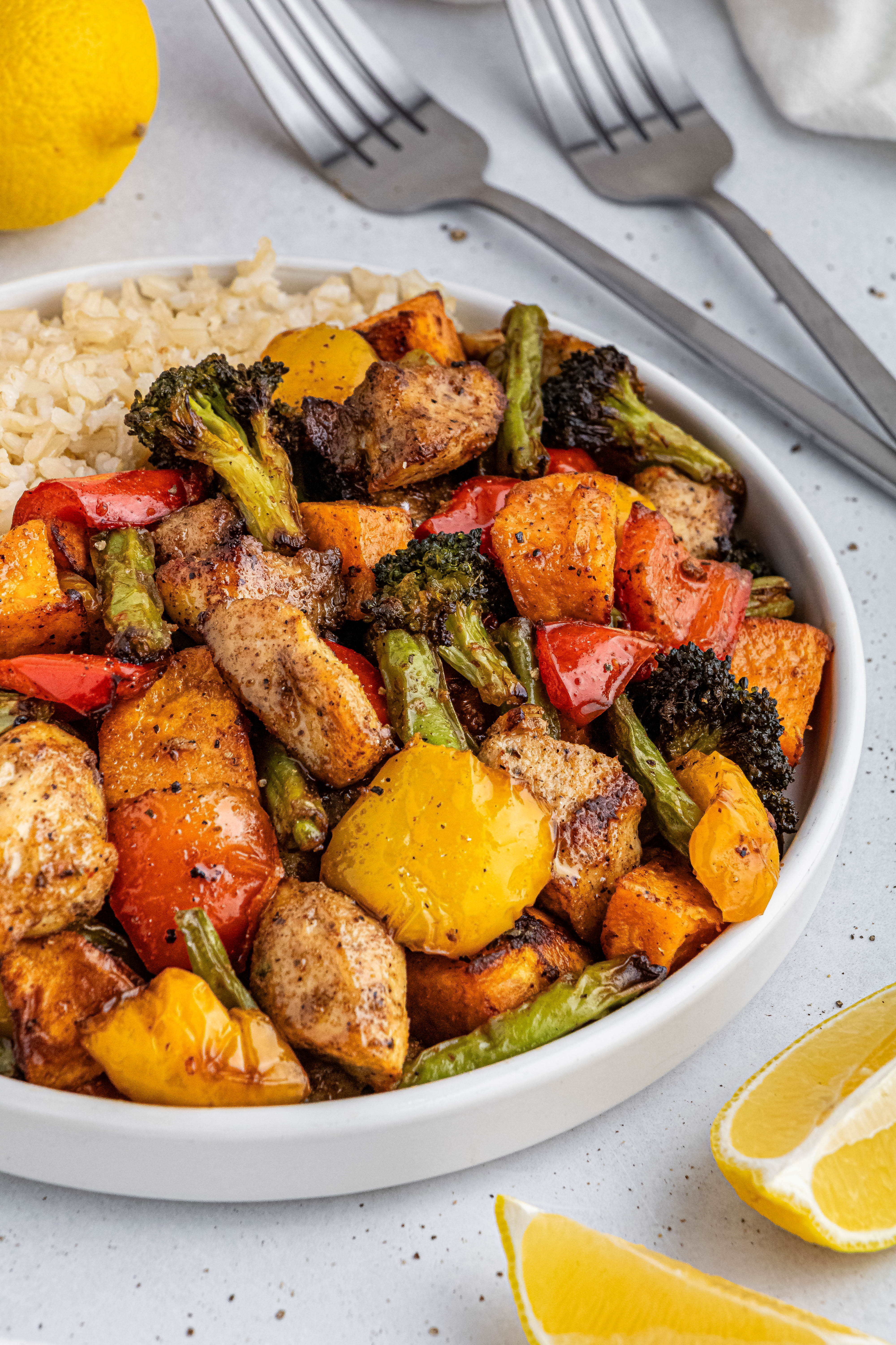 air fryer cajun chicken and peppers on a white plate with rice and broccoli