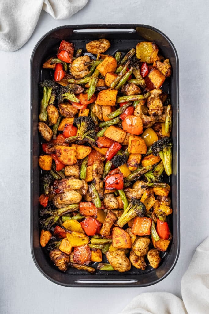 chicken and vegetables sitting in a black air fryer basket