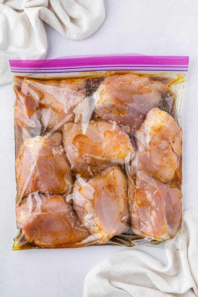 chicken thighs marinated and sitting in a plastic bag