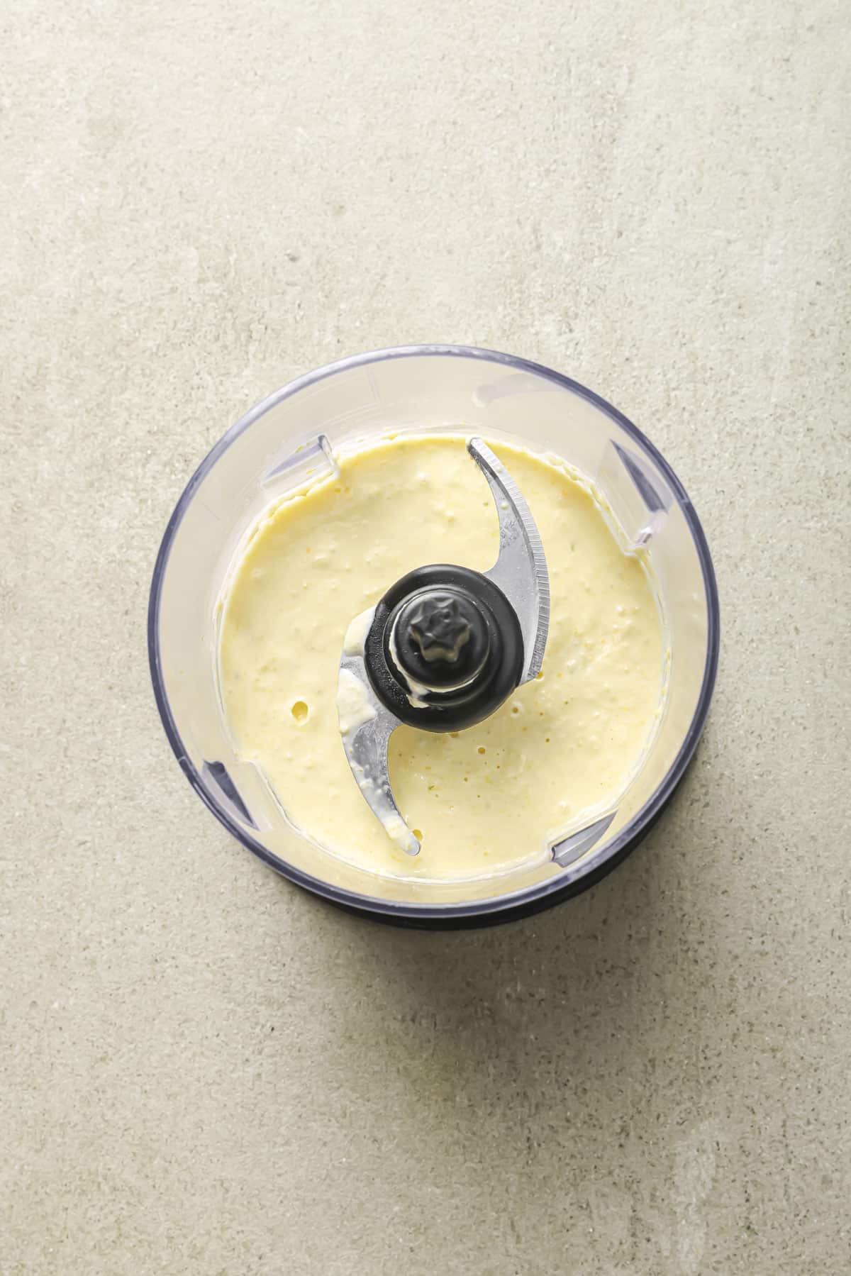 Blending corn kernels with crema in a food processor.