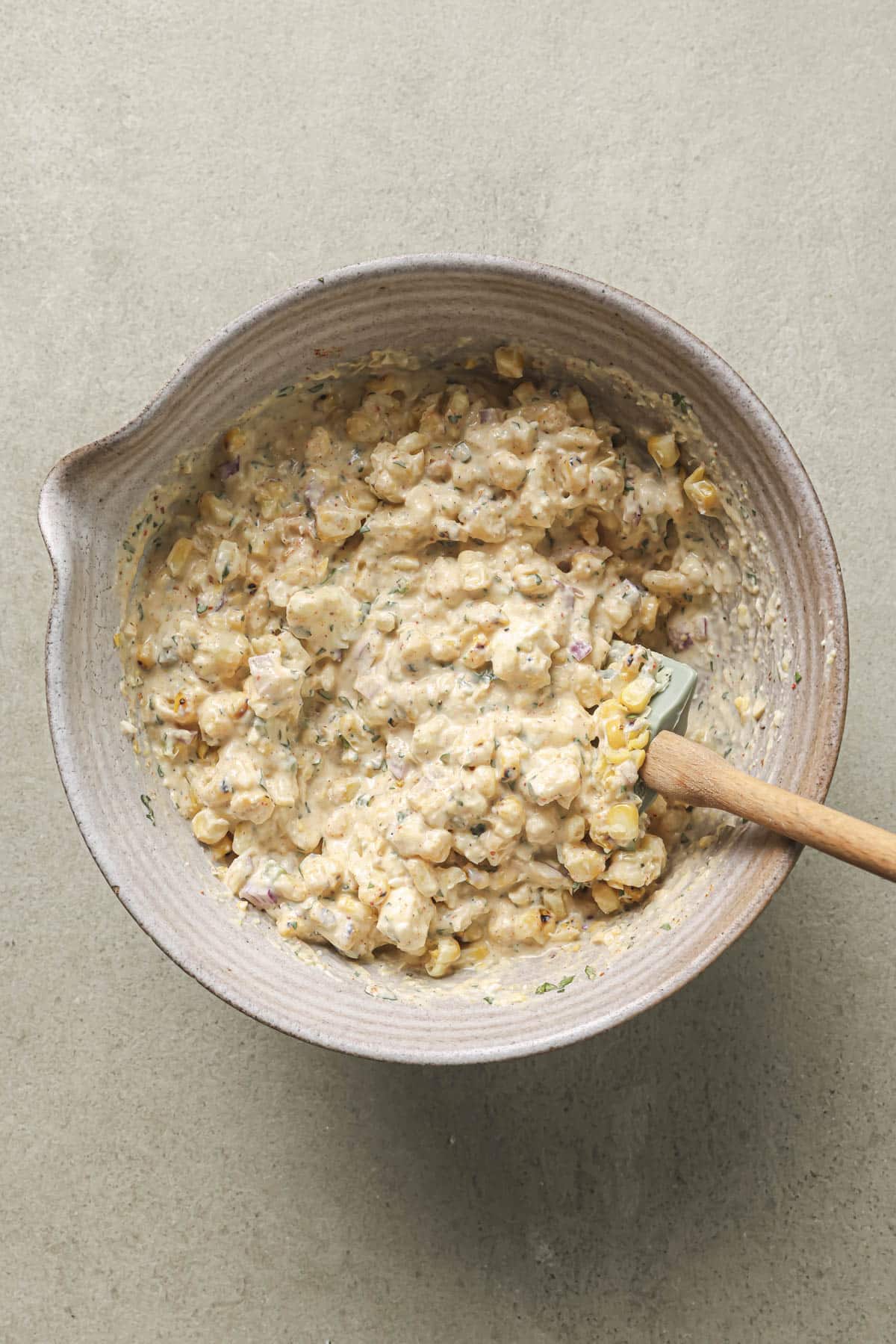 Stirring corn into creamy dip.