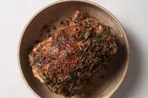 Coating beef brisket with herbs and spices.
