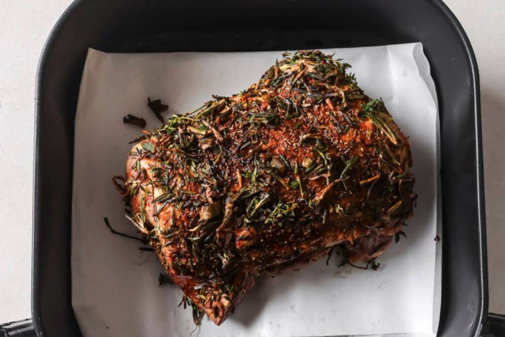 Uncooked beef brisket in the air fryer basket.
