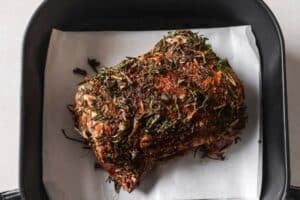 Uncooked beef brisket in the air fryer basket.