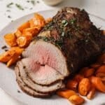Sliced air fryer brisket on a serving platter with carrots.