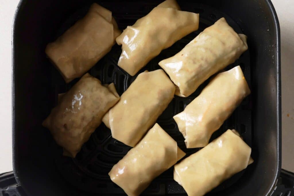 Uncooked egg rolls in the air fryer.