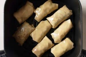 Uncooked egg rolls in the air fryer.