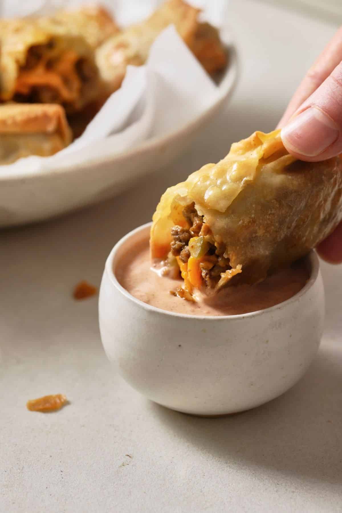 Dipping an egg roll in sauce.