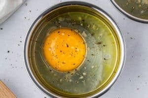 Adding salt and pepper to egg in mini muffin tin.