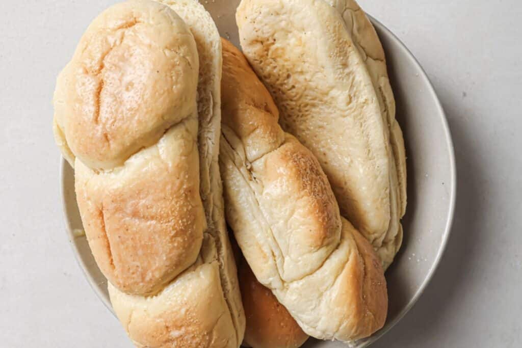 Sliced hoagie rolls in a bowl.