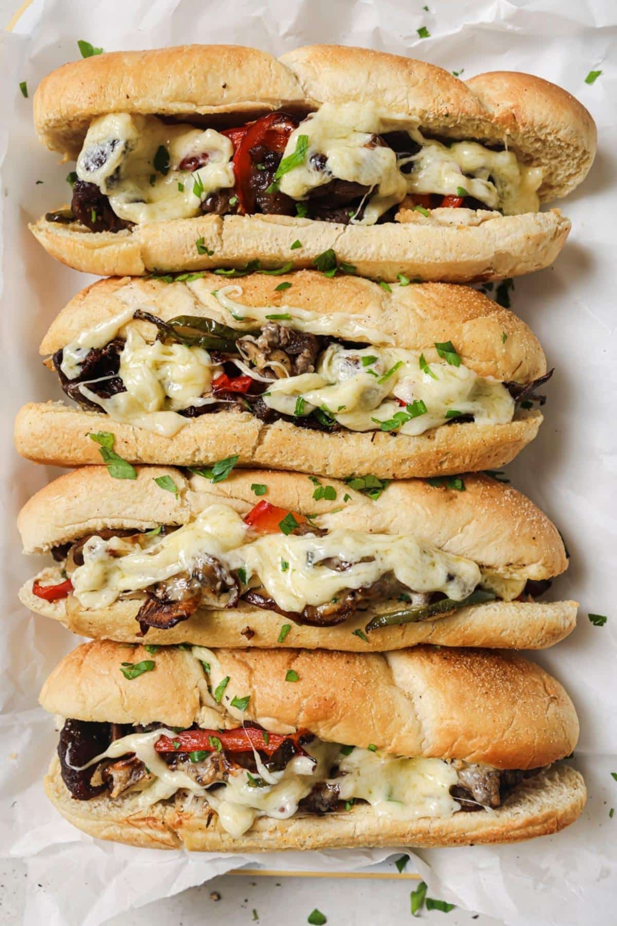 4 air fryer cheesesteaks on parchment paper.