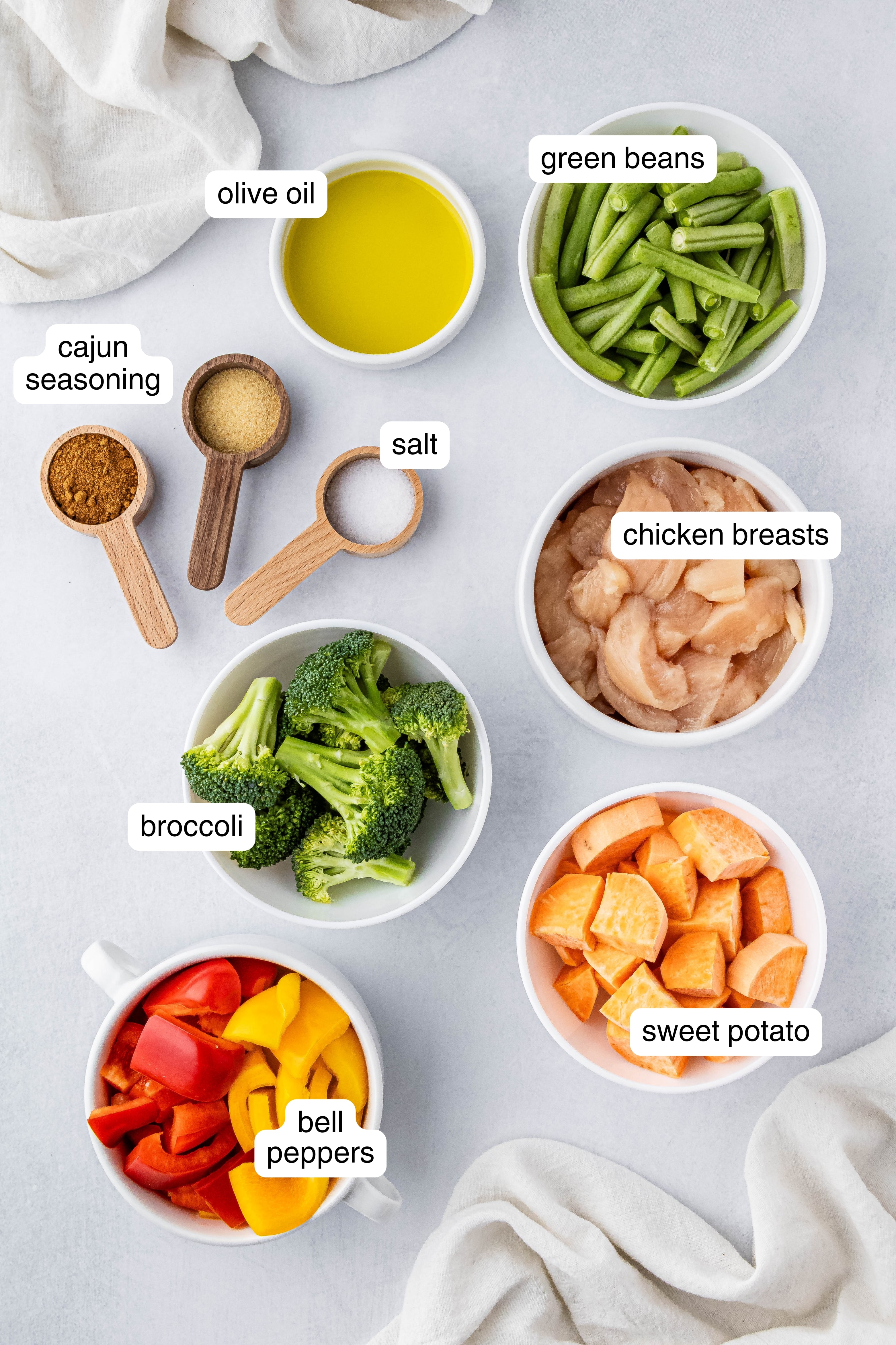 chicken, broccoli, bell peppers, olive oil, and spices in small ingredient bowls