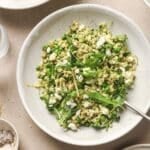 Pearl couscous salad with arugula on a white plate.