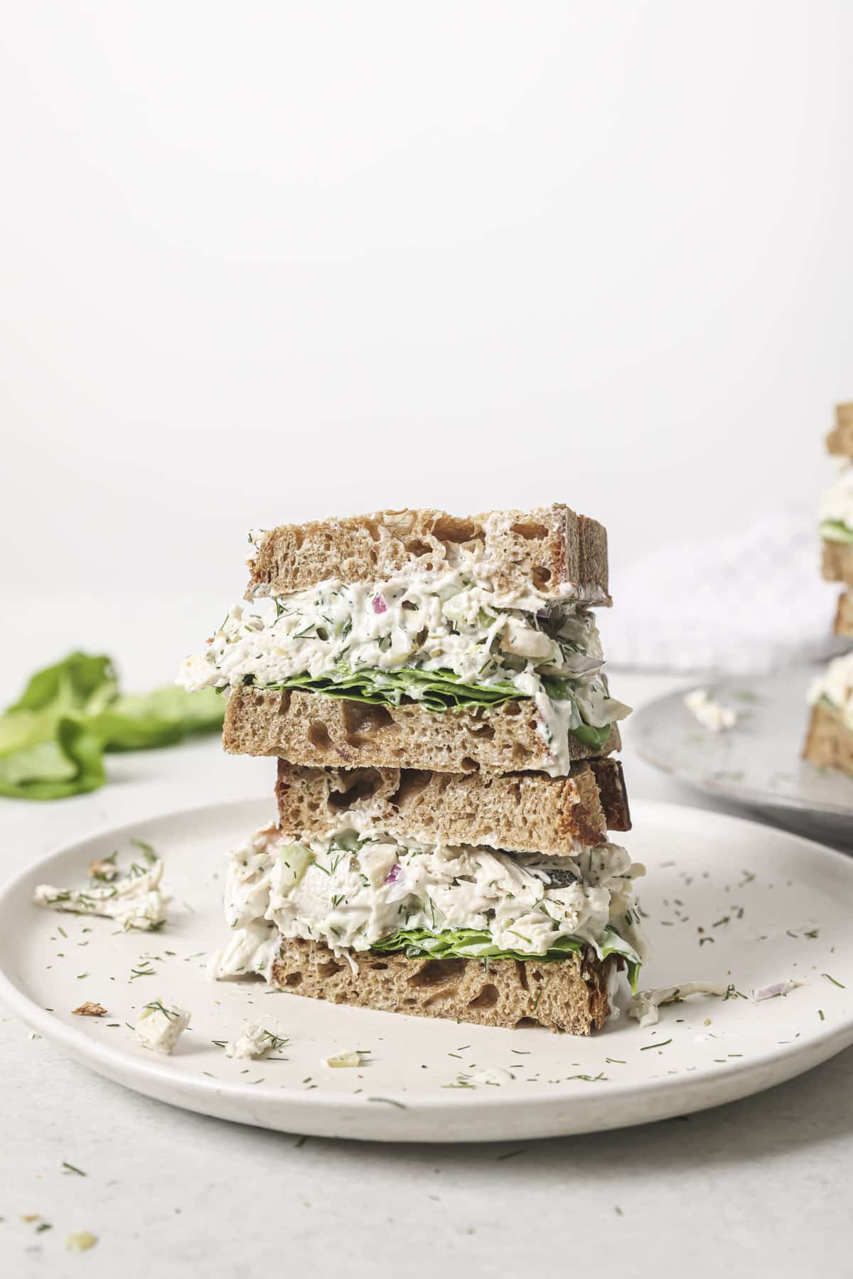 Two dill pickle chicken salad sandwiches stacked.