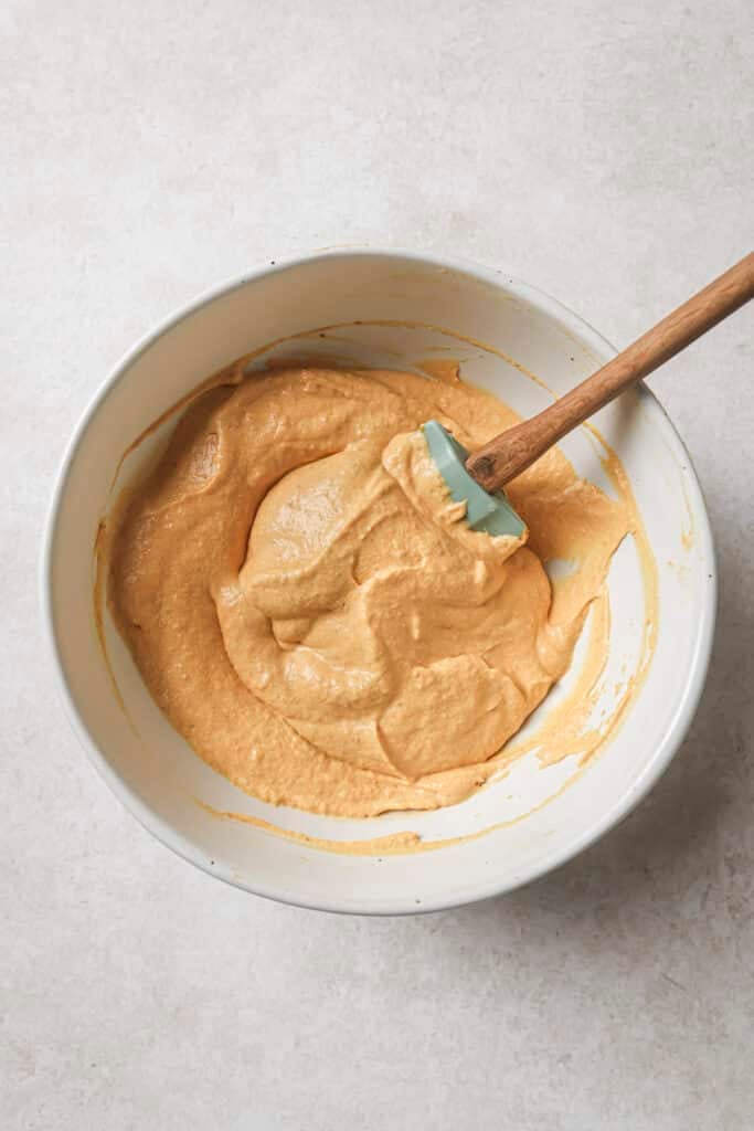 Stirring pumpkin pie filling with cream cheese, Cool Whip and vanilla extract.