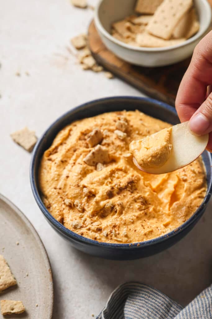 Dipping an apple slice into pumpkin pie dip.
