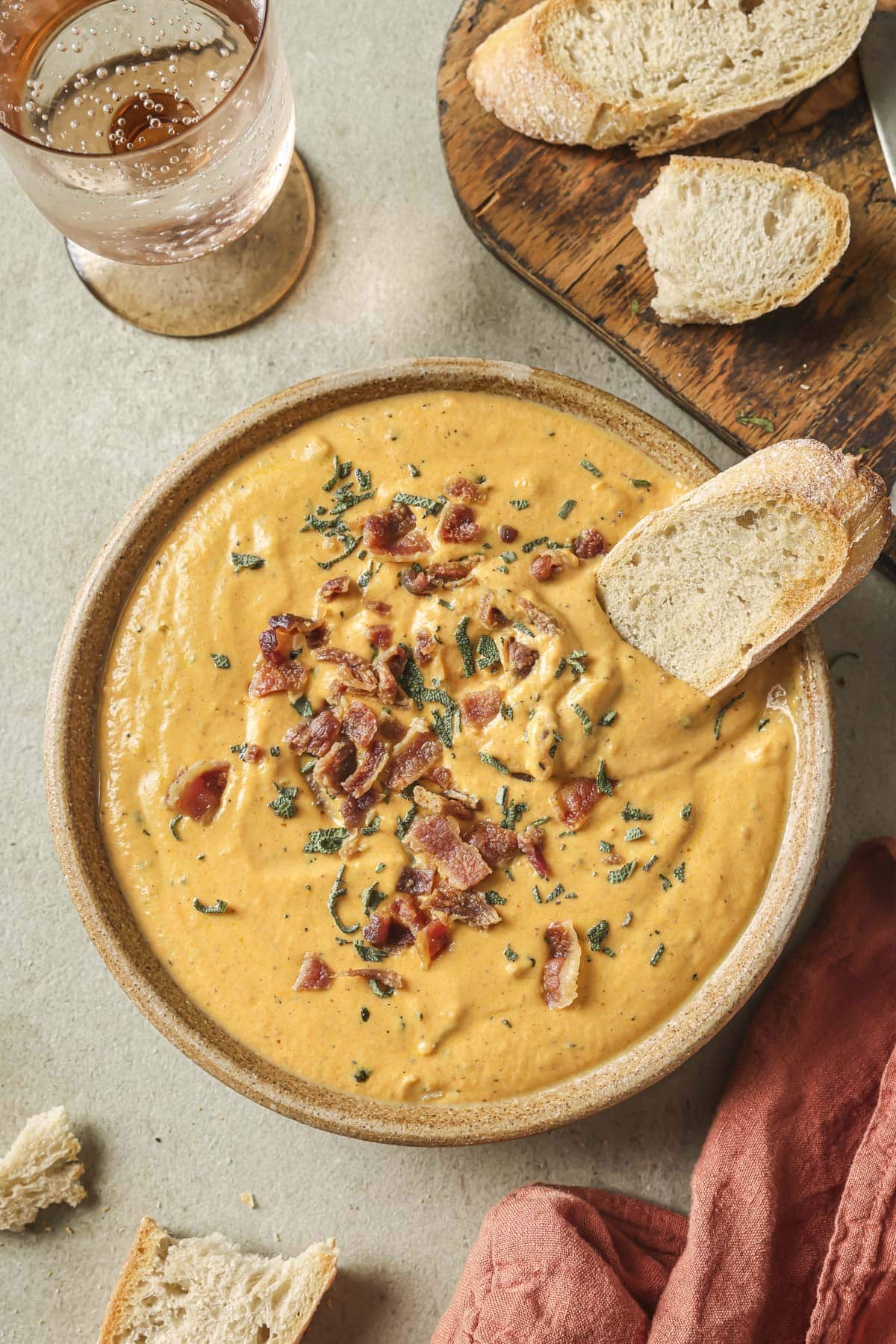 Savory pumpkin dip garnished with bacon and served with toasted bread.