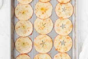 Adding cinnamon to apple slices.