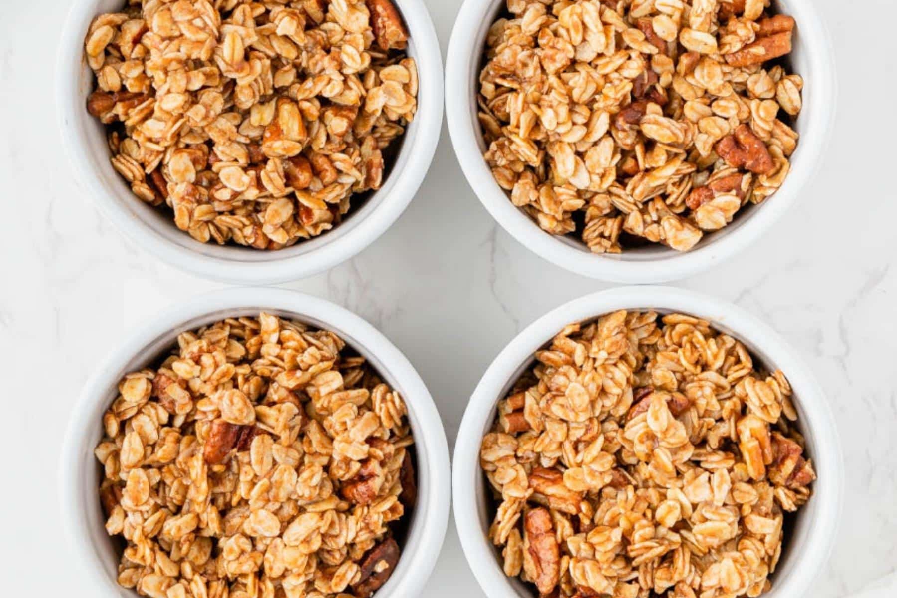 Adding apple filling and oat topping to ramekins.