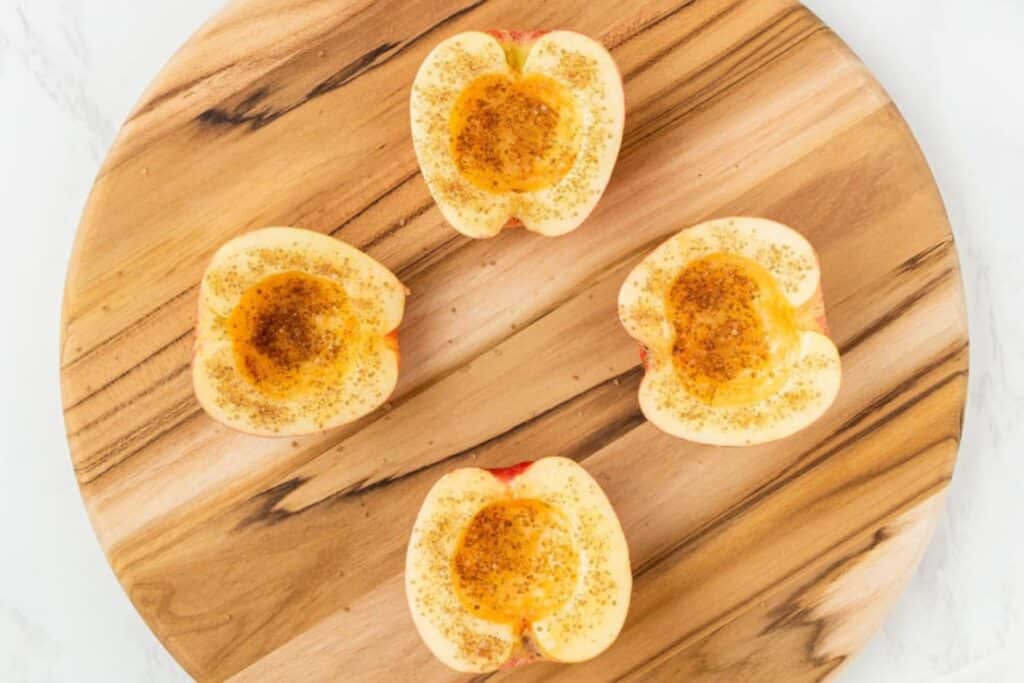 Adding butter and spices to cored apples.