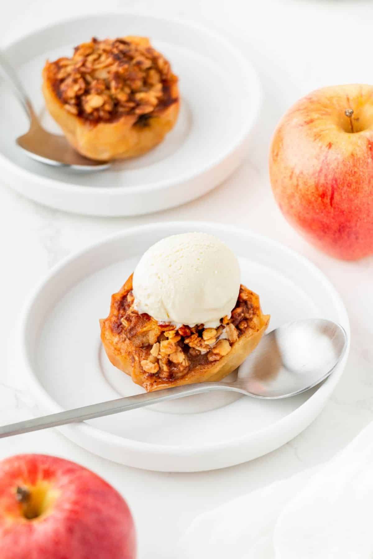 Two plates of air fryer baked apples, one with a scoop of vanilla ice cream.
