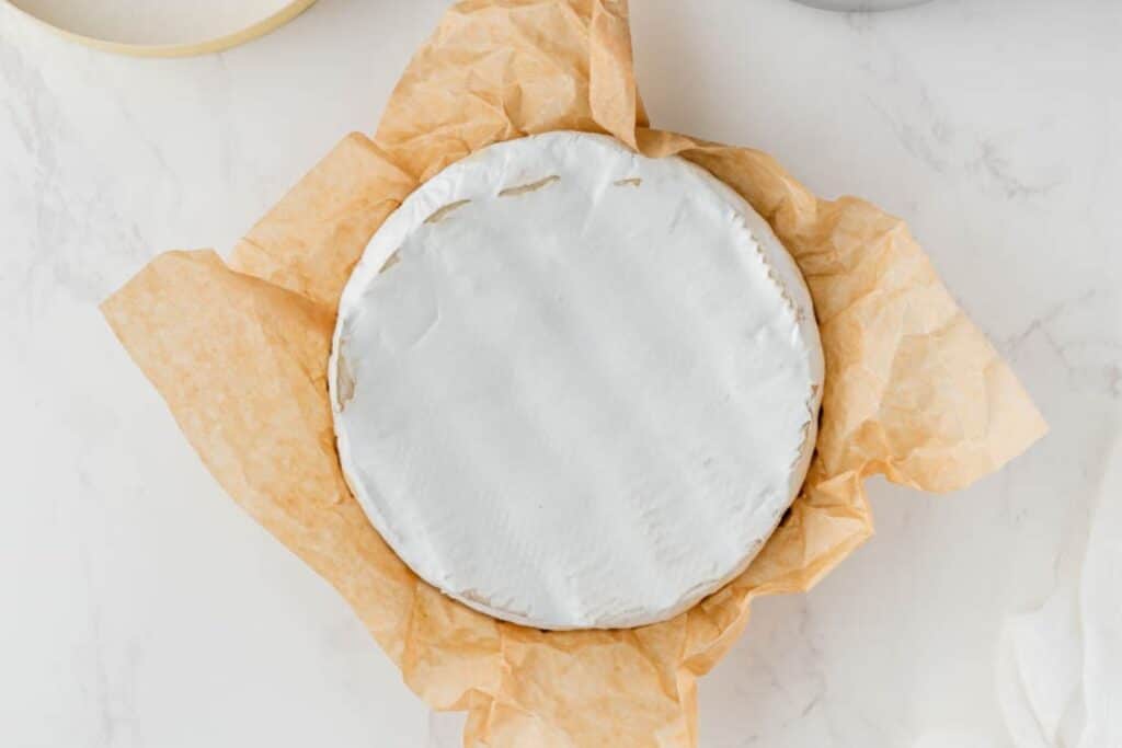 Scoring a wheel of brie.