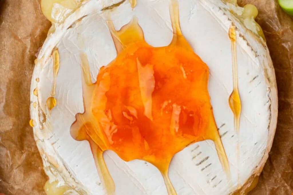Adding apricot preserves to brie.