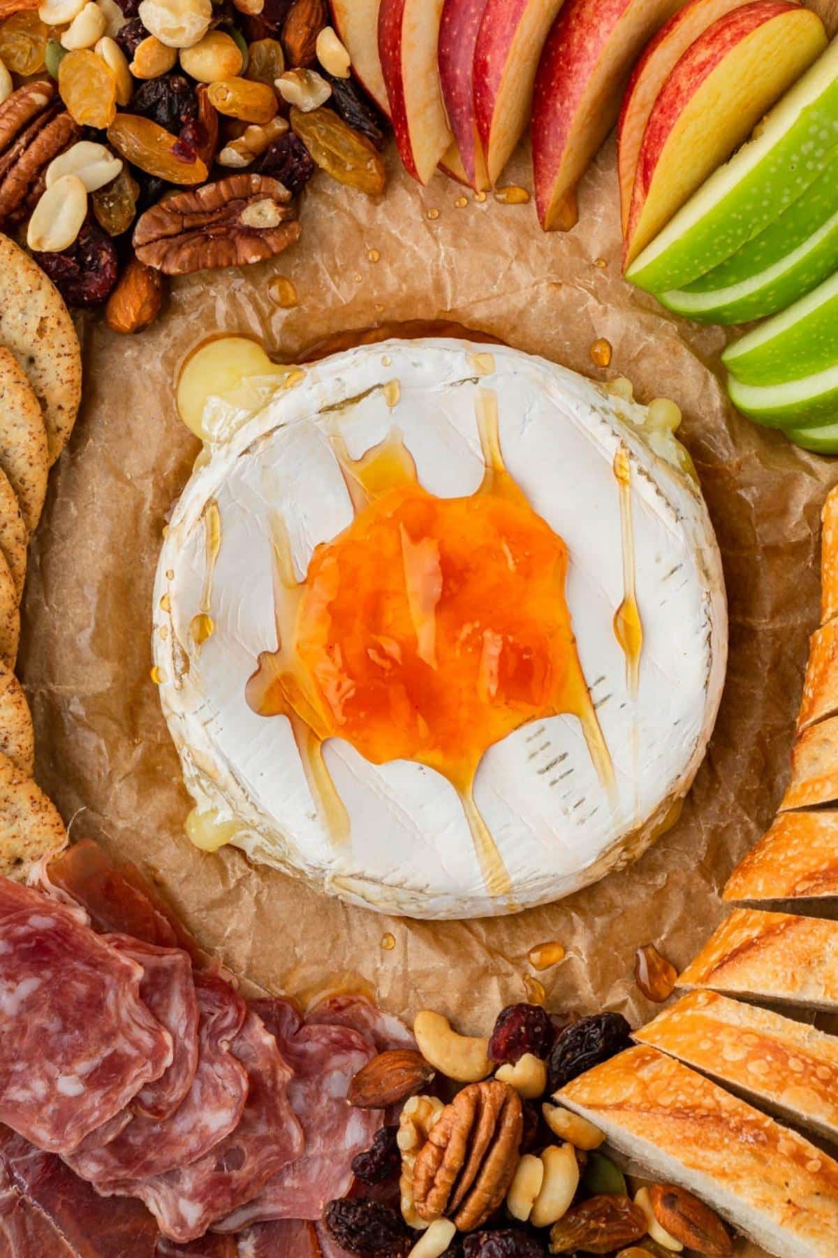 Air fryer baked brie with apricot preserves served on a snack board.
