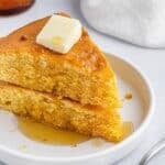 A plate with two slices of cornbread.