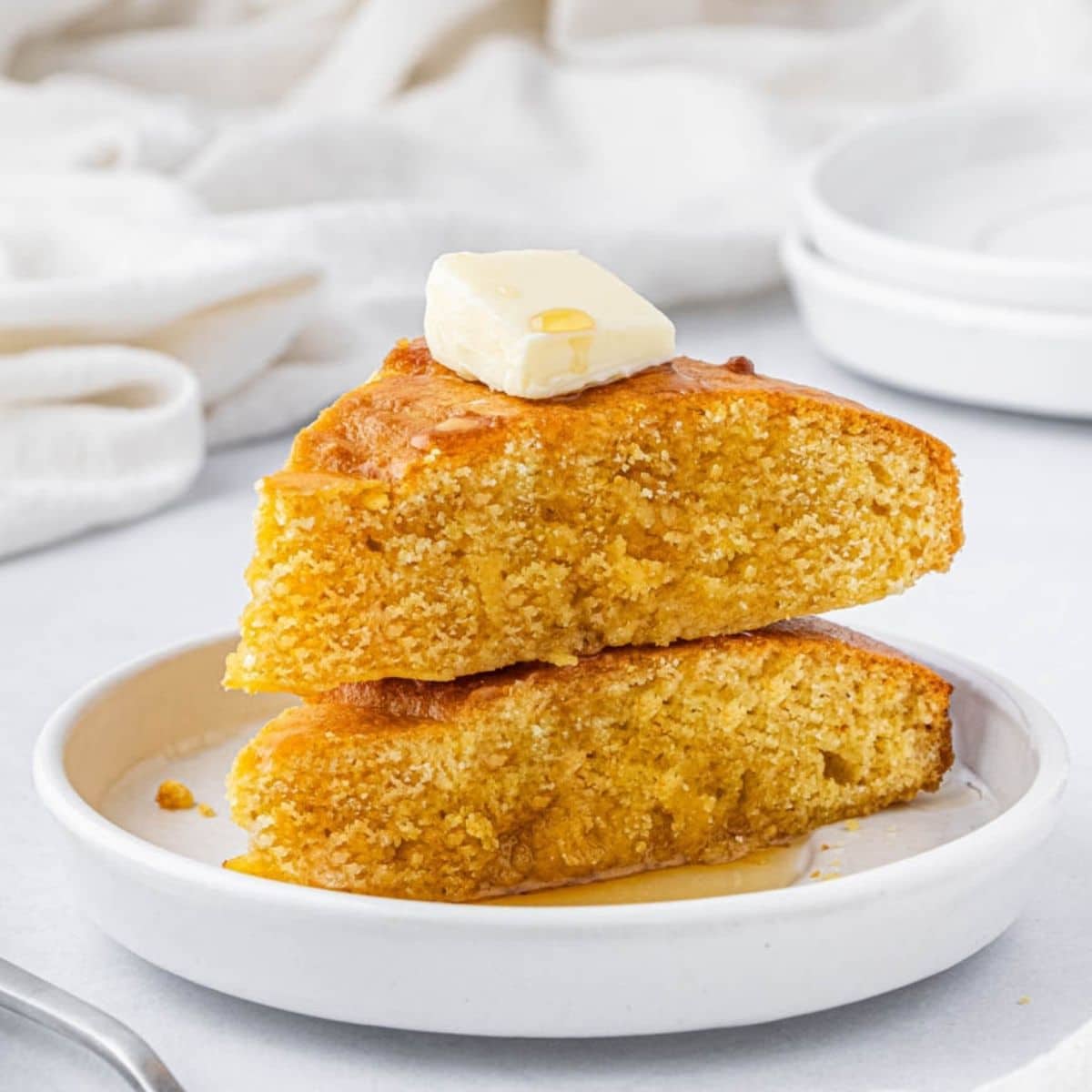 Two slices of air fryer cornbread on a white plate.