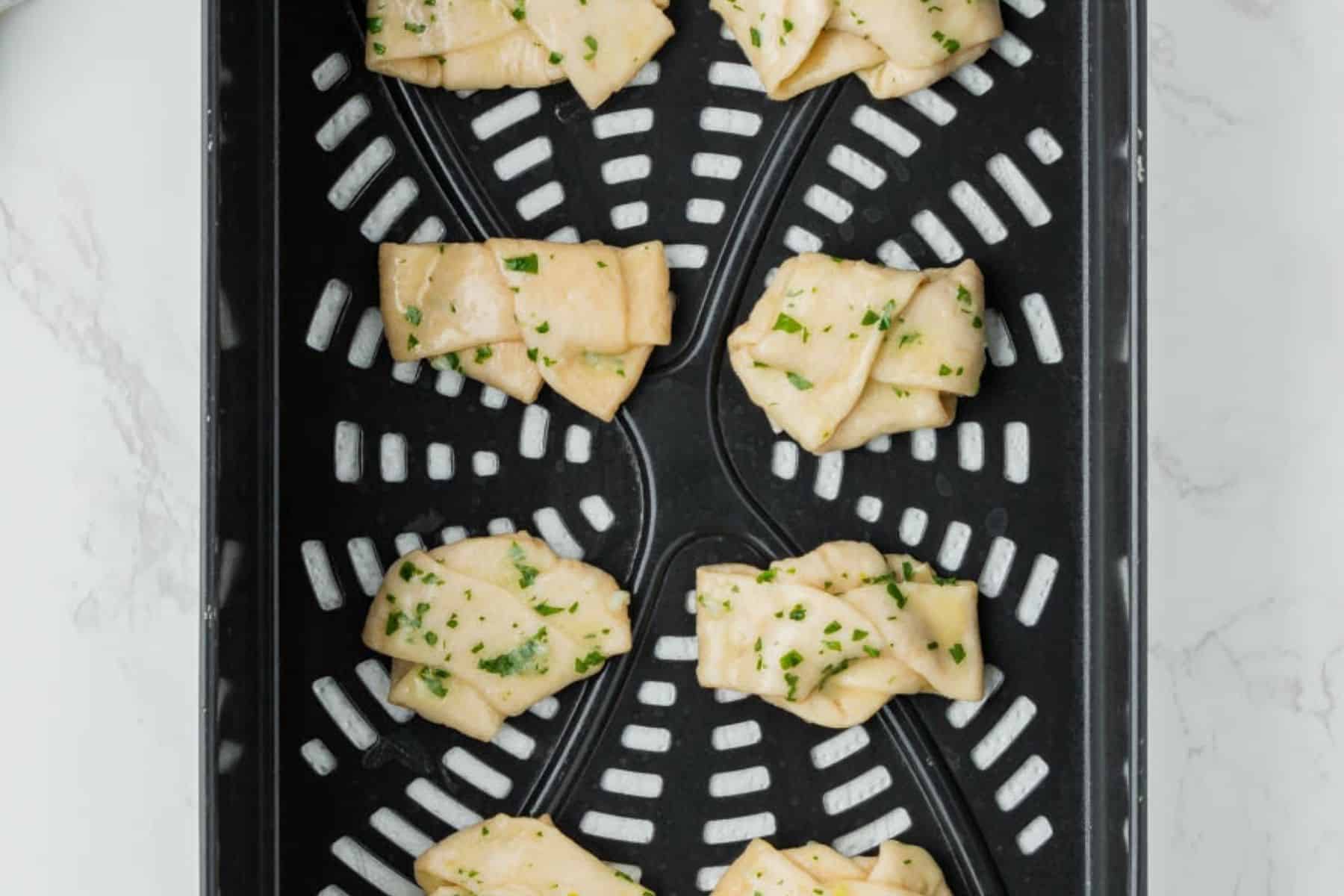 Uncooked garlic knots in the air fryer.