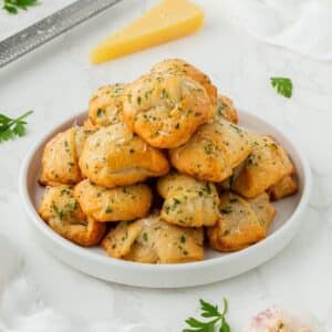 Air fryer garlic knots stacked high on a plate.