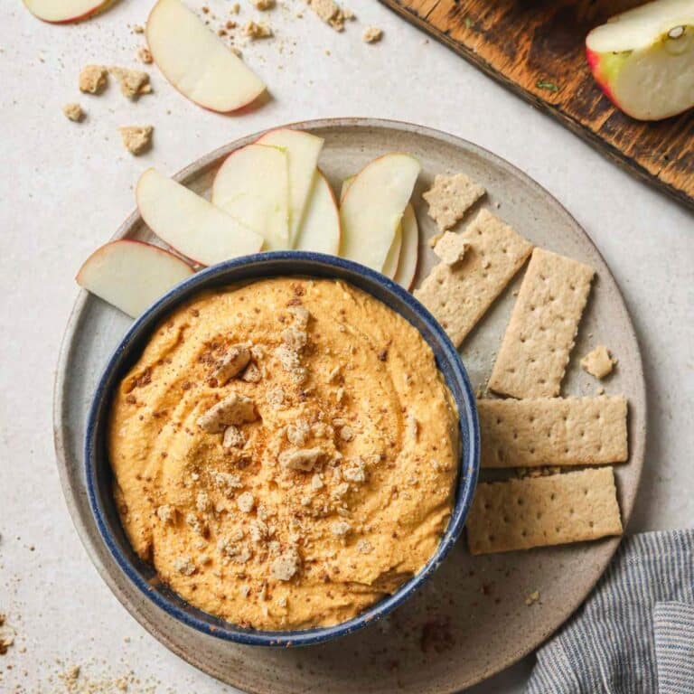 Pumpkin pie dip served with graham crackers and apple slices.