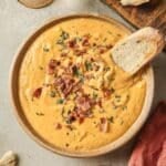 Savory pumpkin dip garnished with bacon and served with toasted bread.