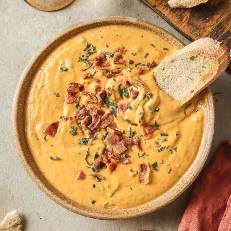 Savory pumpkin dip garnished with bacon and served with toasted bread.