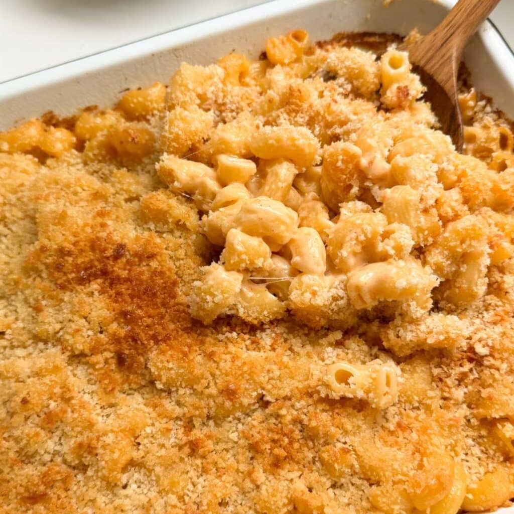 Buffalo mac and cheese being served on a wooden spoon.