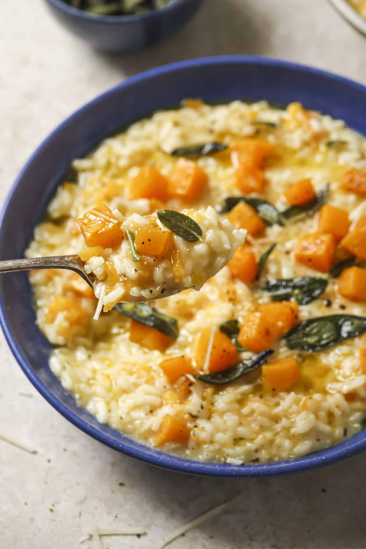 Spooning risotto out of a bowl.