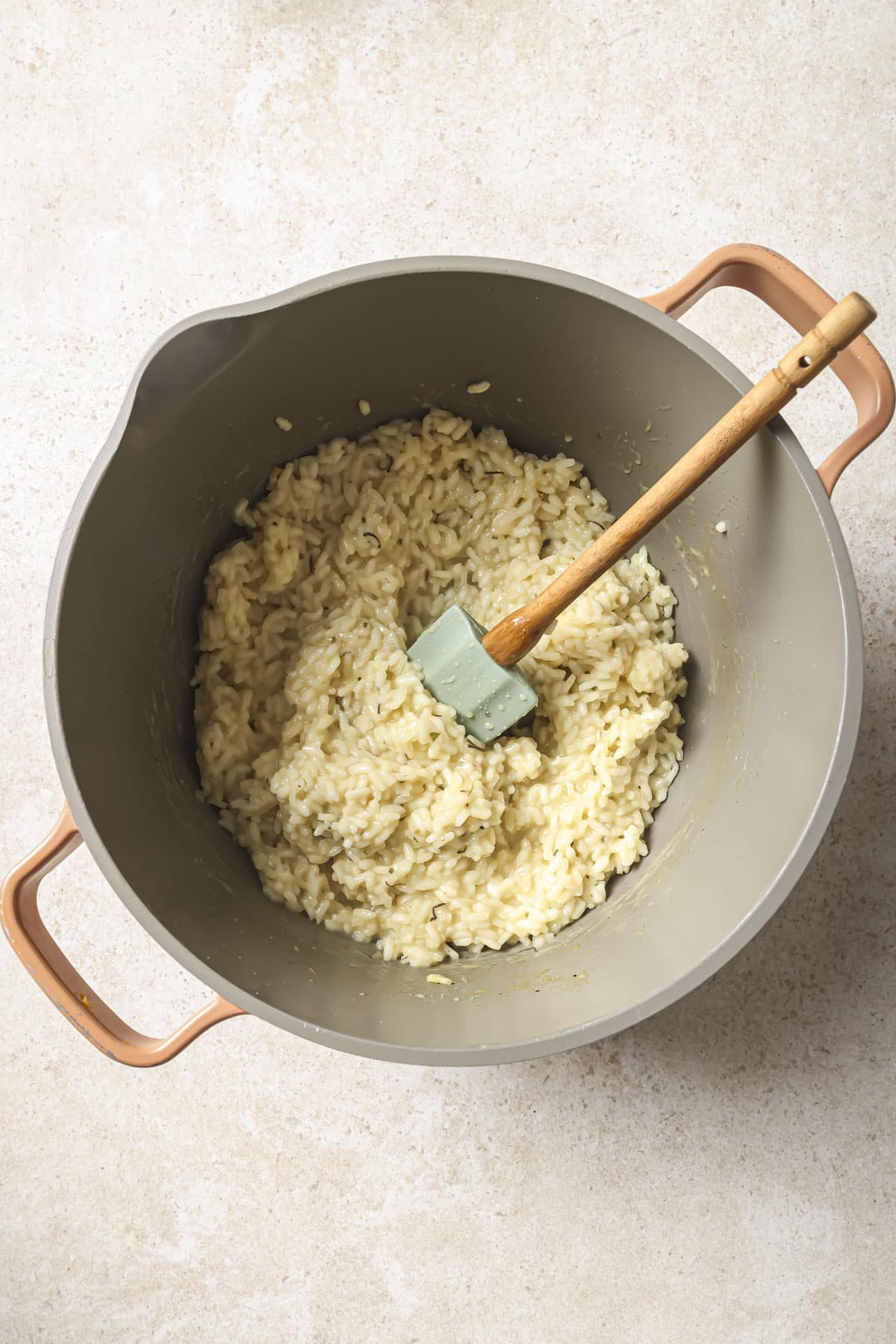 Stirring arborio rice with wine and broth in a large pot.
