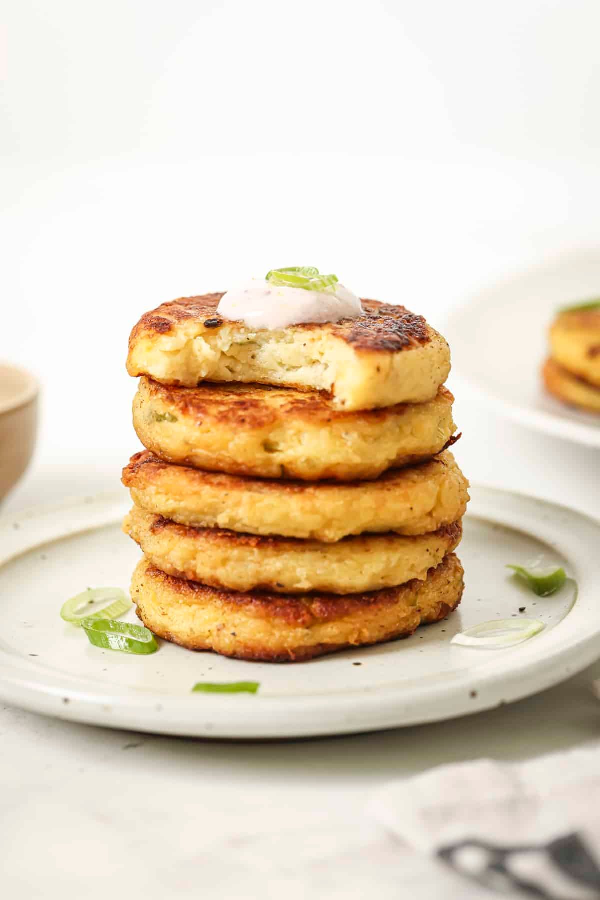 Stacked potato cakes with a dollop of creamy sauce on top.