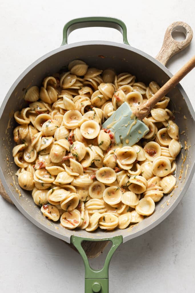 Stirring pasta with sauce.