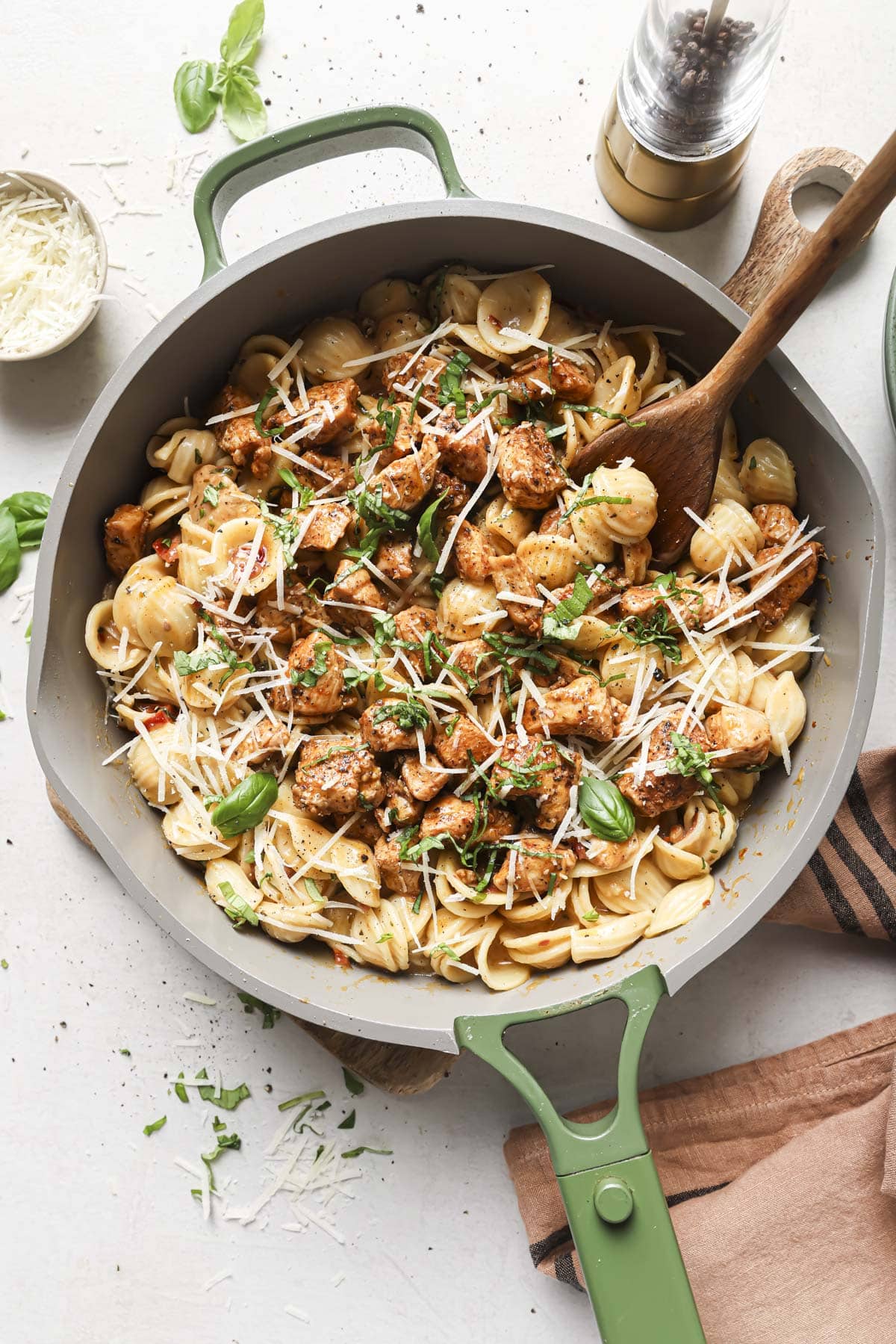 Marry me chicken pasta in a skillet with a wooden spoon.
