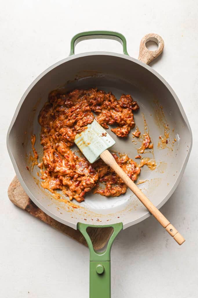 Sautéing seasonings with  sun-dried tomatoes and flour.