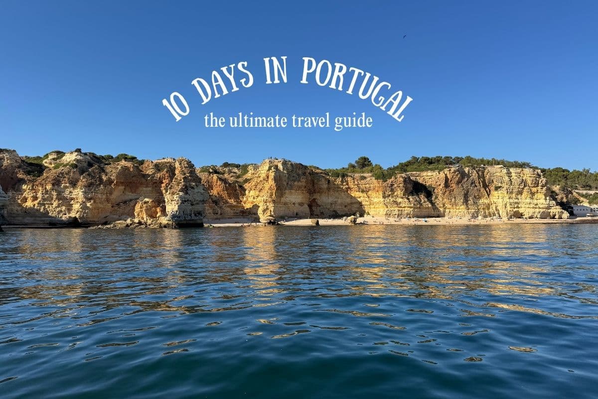 Scenic coastal cliffs in Portugal reflecting on the calm blue ocean under a clear sky, with white text overlay reading “10 Days in Portugal – the ultimate travel guide.