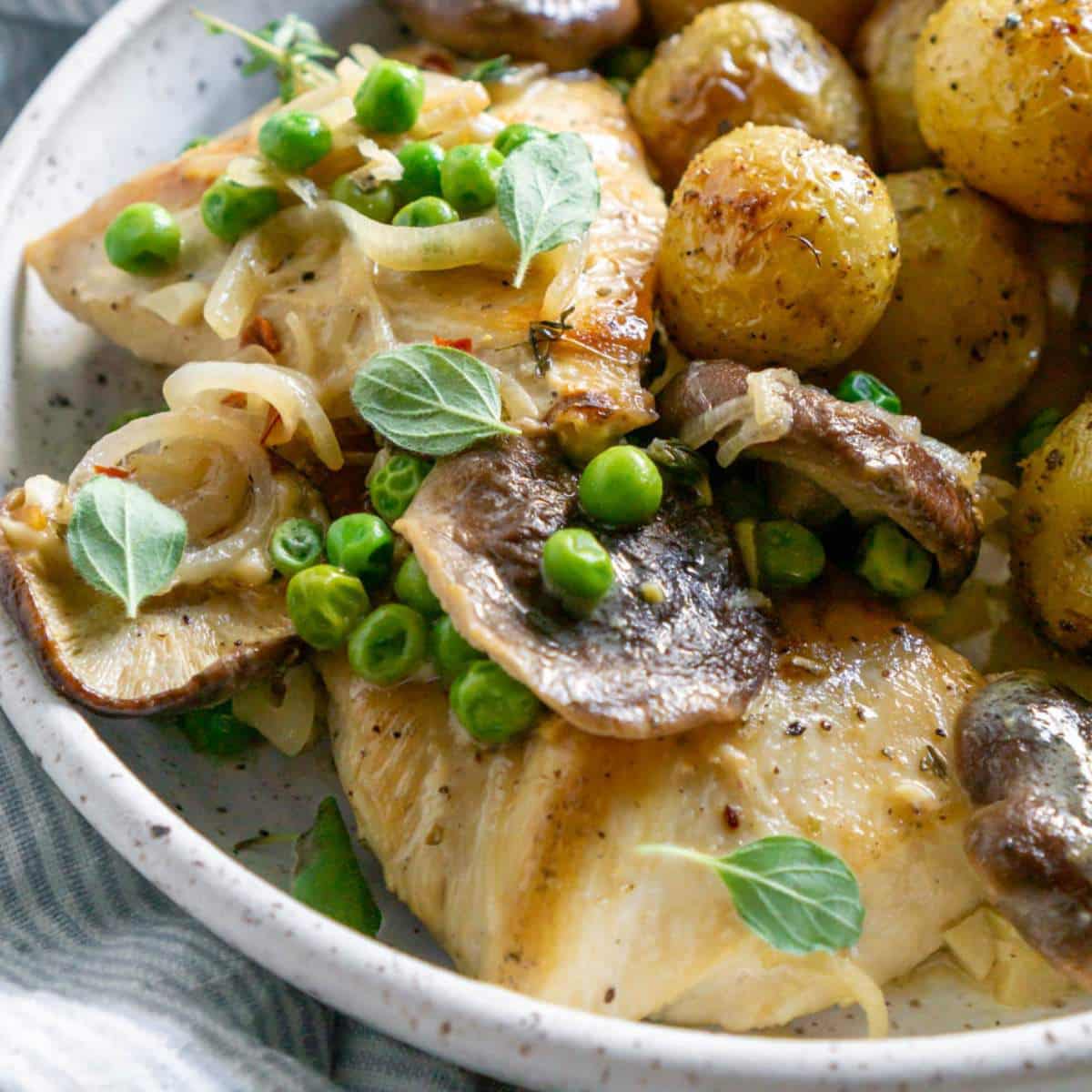 Chicken served with potatoes and peas.