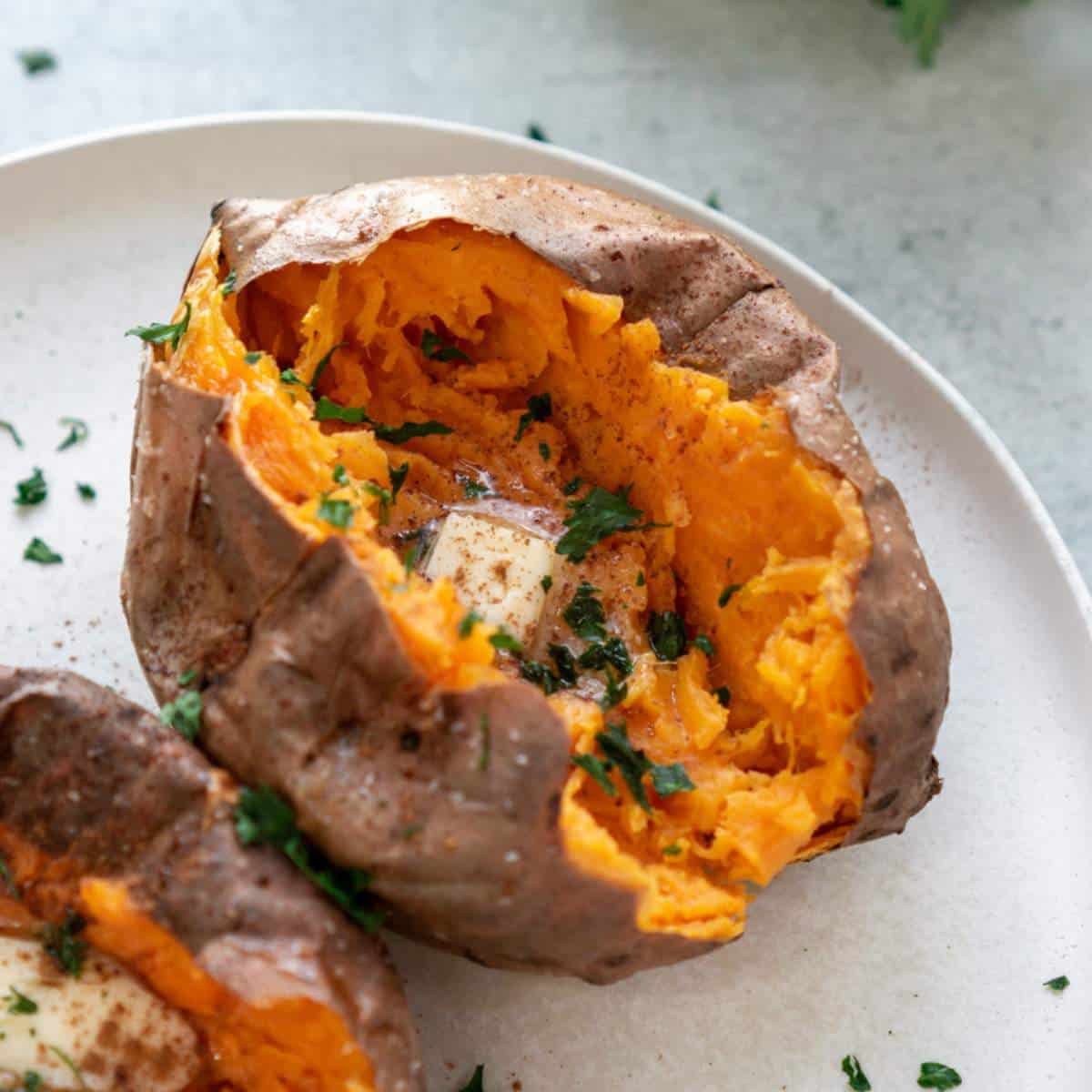 Sweet potatoes with butter on a white plate.