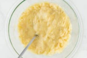 Mashing bananas in a glass bowl.