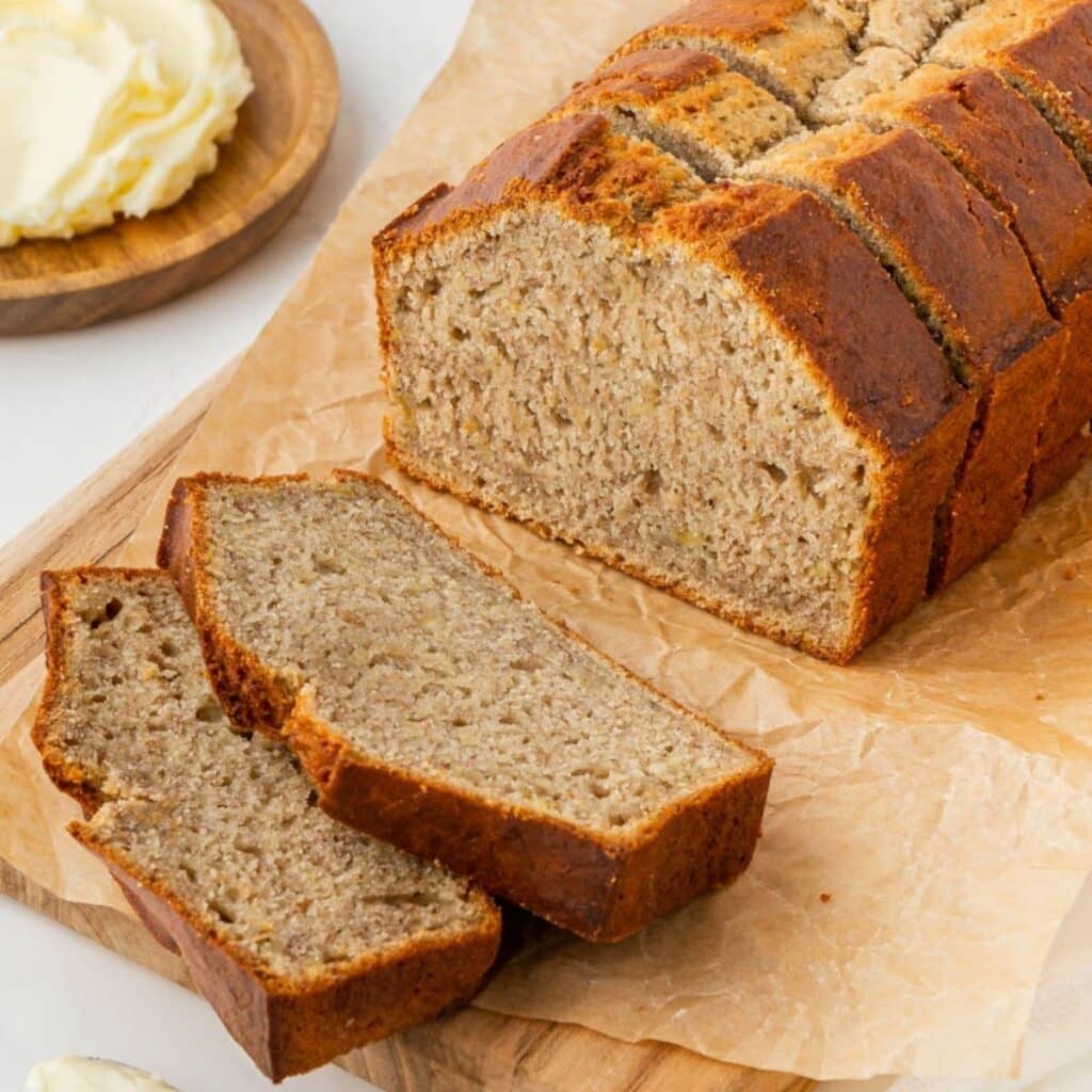 Slices of banana bread on a parchment covered cutting board.