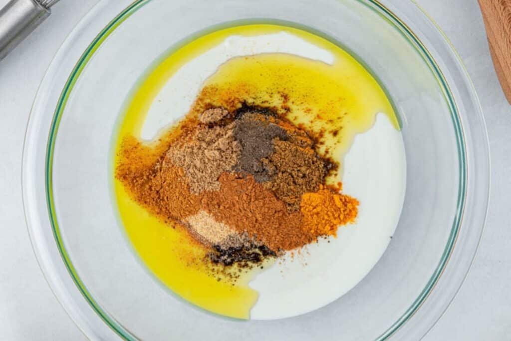 Mixing spices in a bowl with oil and greek yogurt.