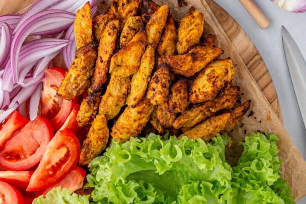 Air fried chicken shawarma with onions, tomato, and lettuce.
