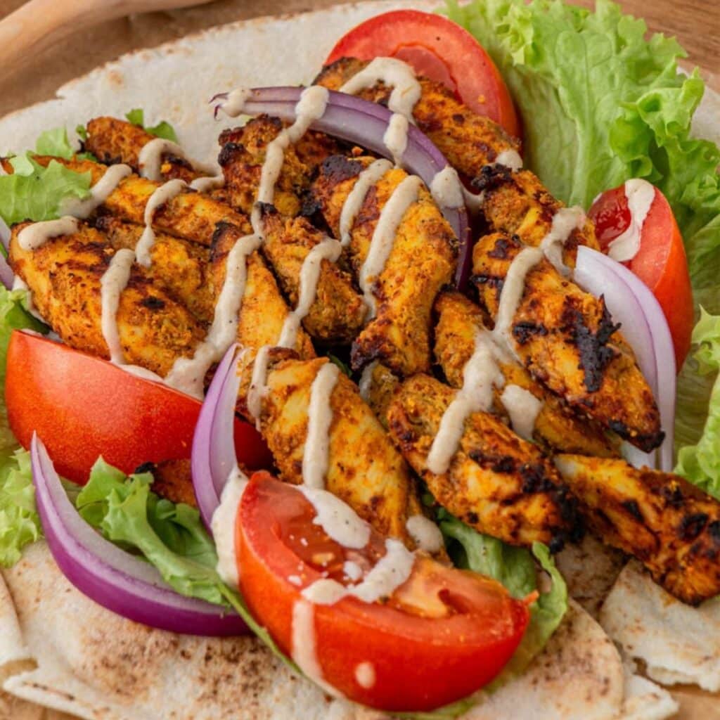 Close up of air fryer chicken shawarma with tahini sauce.